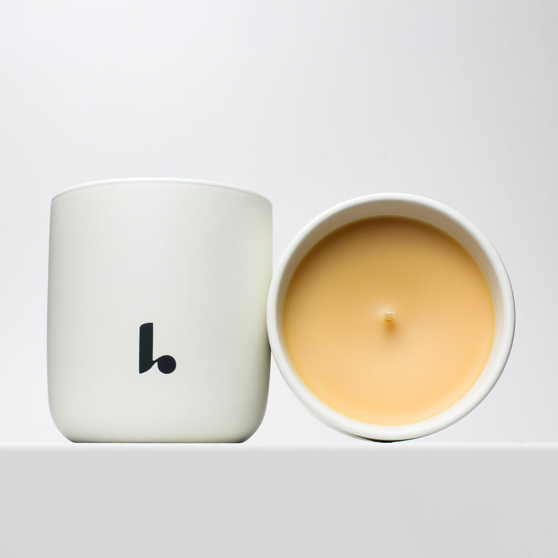 In Paradisum scented candle with yellow soy wax housed in a white ceramic vessel