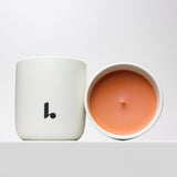 Midnight Embers scented candle with orange soy wax housed in a white ceramic vessel
